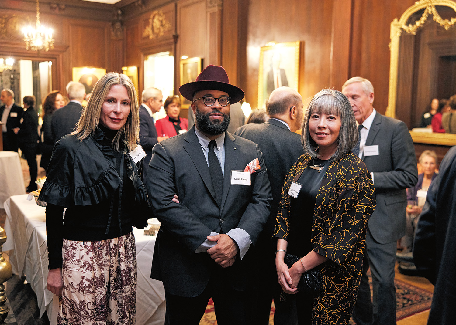 Christine David, Kevin Young, and Cynthia Chavez Lamar face the viewer in a group shot. They smile and are dressed in cocktail attire. Behind them is an event room filled with other attendees at the launch of the final report of the Commission on Accelerating Climate Action.