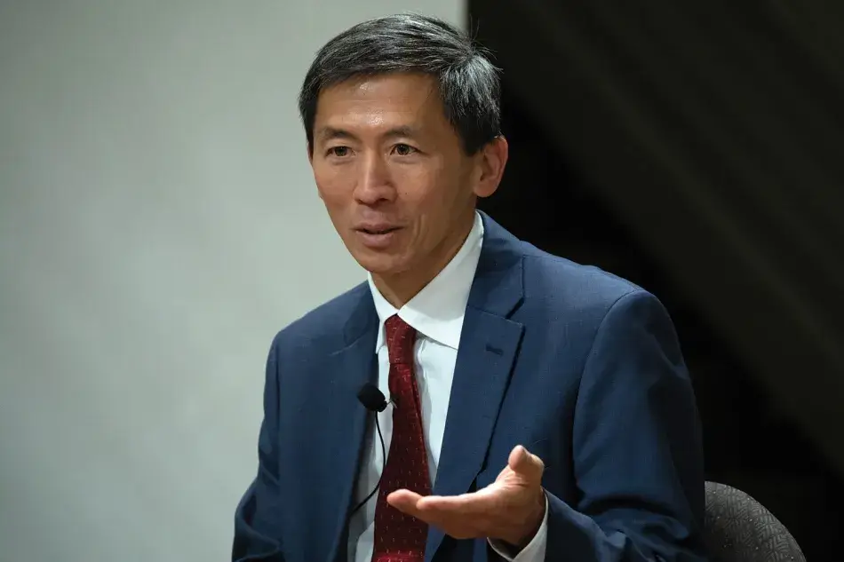 A photo of Associate Justice Goodwin H. Liu, a man with brown skin and short dark hair. He wears a red tie, a white shirt, and a dark blue suit. A microphone is clipped to his tie. Photo by Martha Stewart Photography.