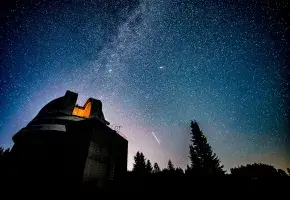 Night sky with stars and observatory.