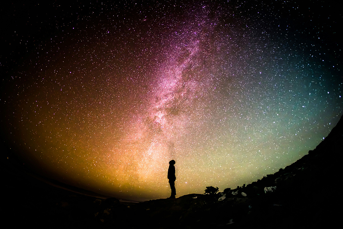 Silhouette photography of person against a bright night sky.